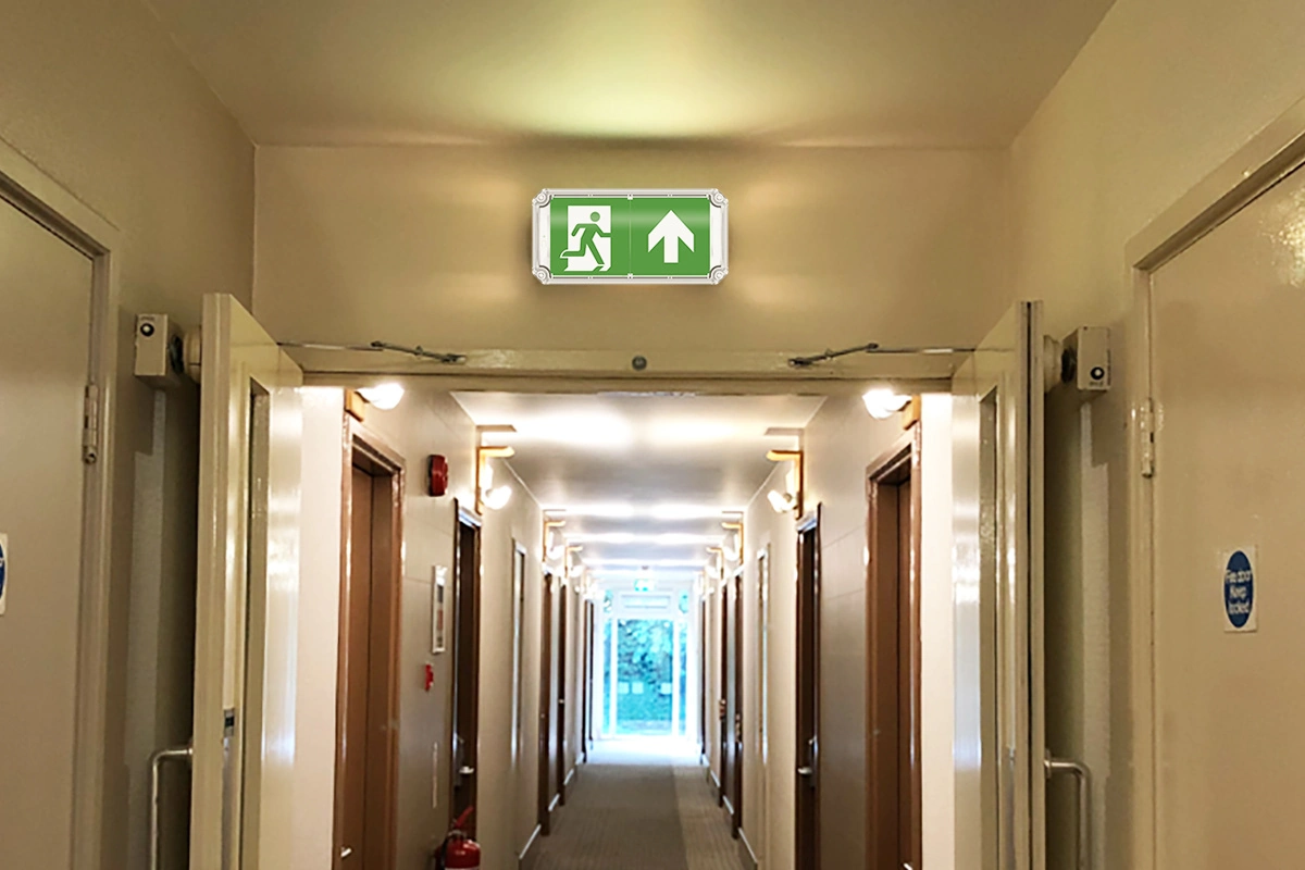 surface-mounted IP66 emergency exit sign in hotel corridor